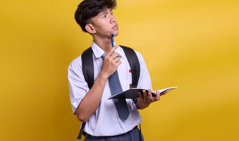 Indonesian high school student uniform thinking while holding book looking up